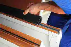 Garage door weather stripping replacement in maricopa county safari garage door and gate safari garage door and gate Technician installing new bottom rubber weather seal on residential garage door in Mesa Arizona