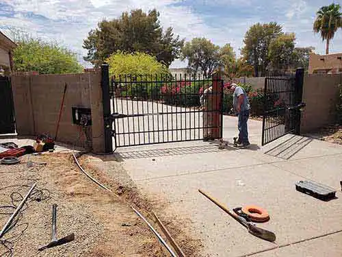 A beautiful luxury double swing custom iron estate gate lacking an automatic opener system in Scottsdale